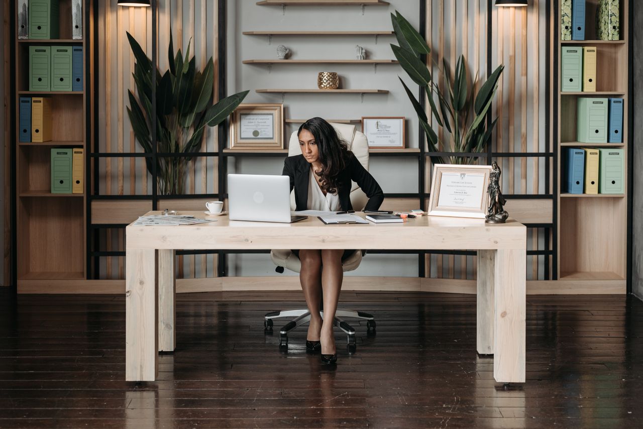 Crafting Captivating Headlines: Your awesome post title goes here Businesswoman in a stylish office working on a laptop, surrounded by office supplies.